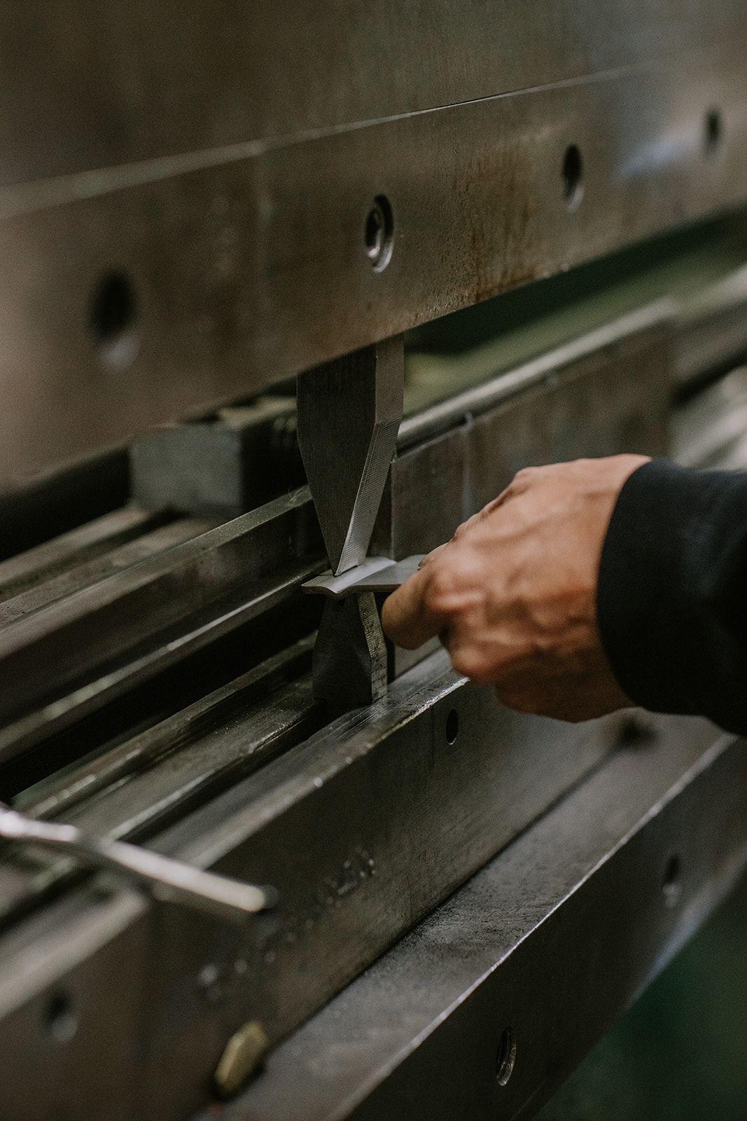 Close-up shop operation on metal fabrication equipment.