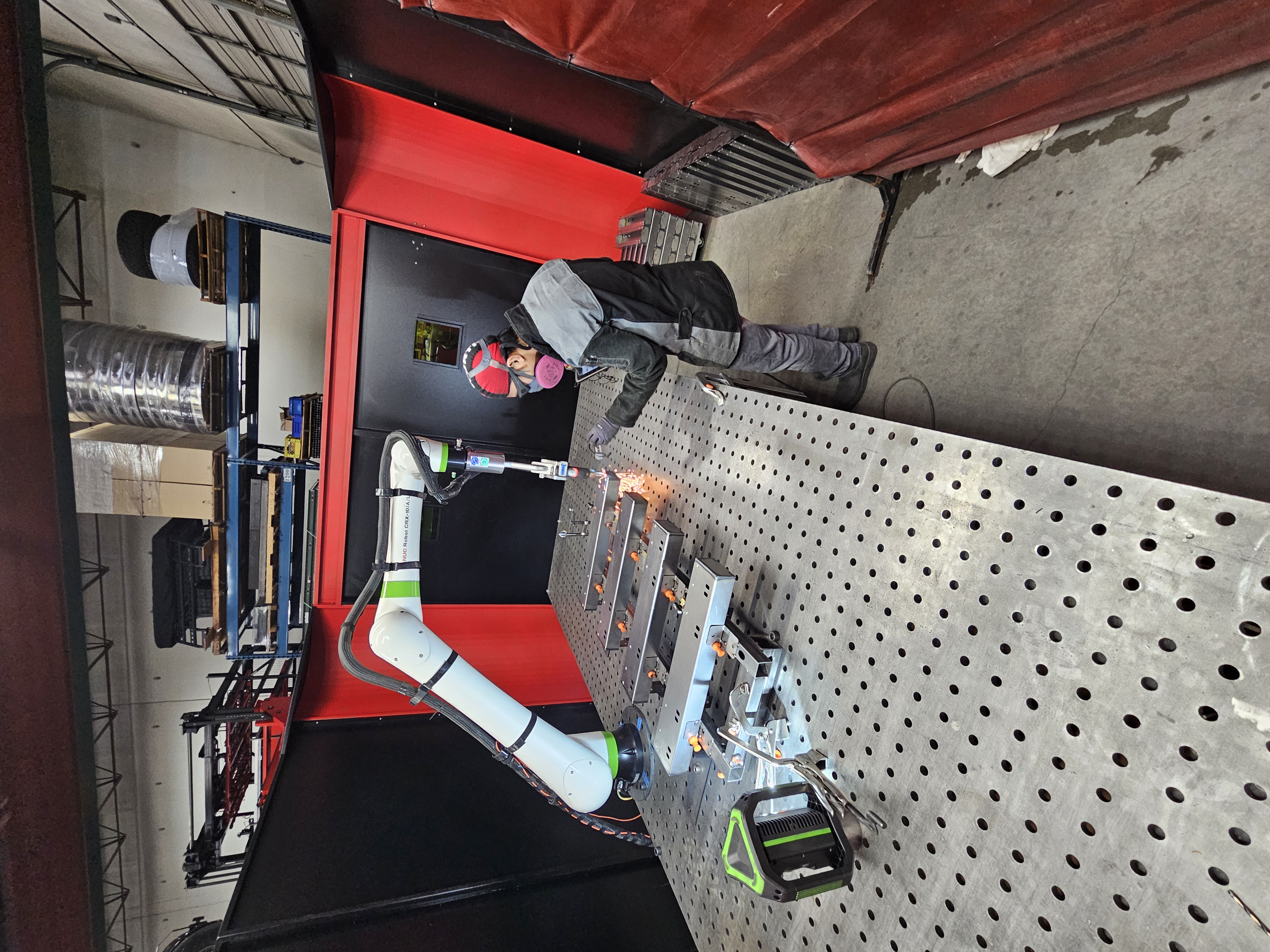 Robotic laser welding cell supporting automated metal fabrication work.